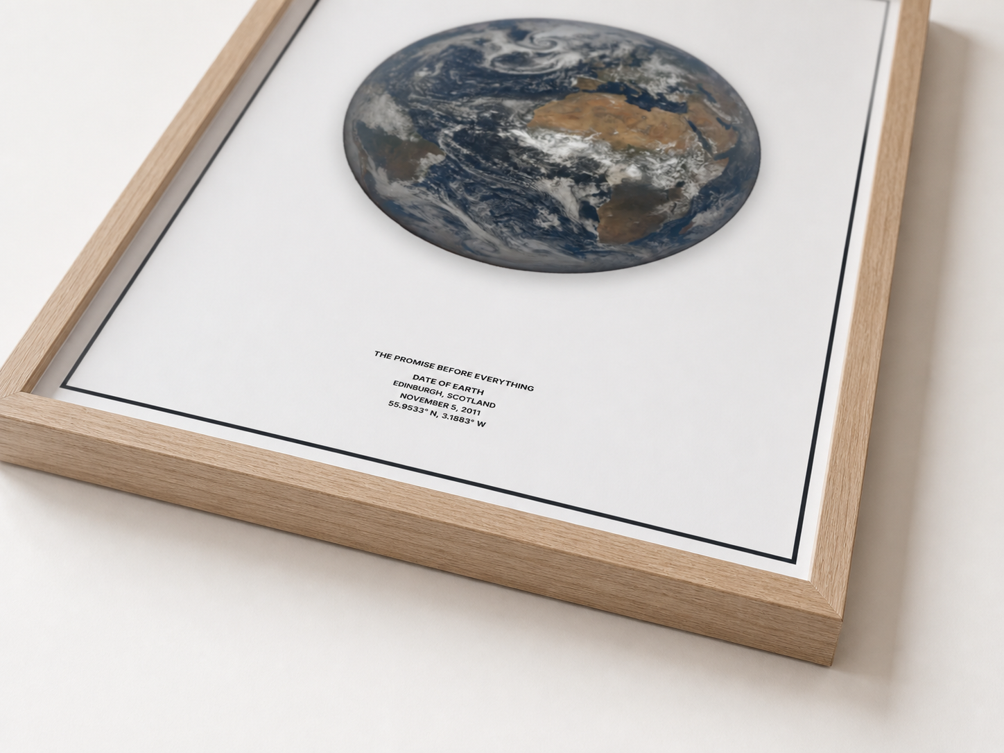 Close view of a natural wood frame around a Date of Earth print.
