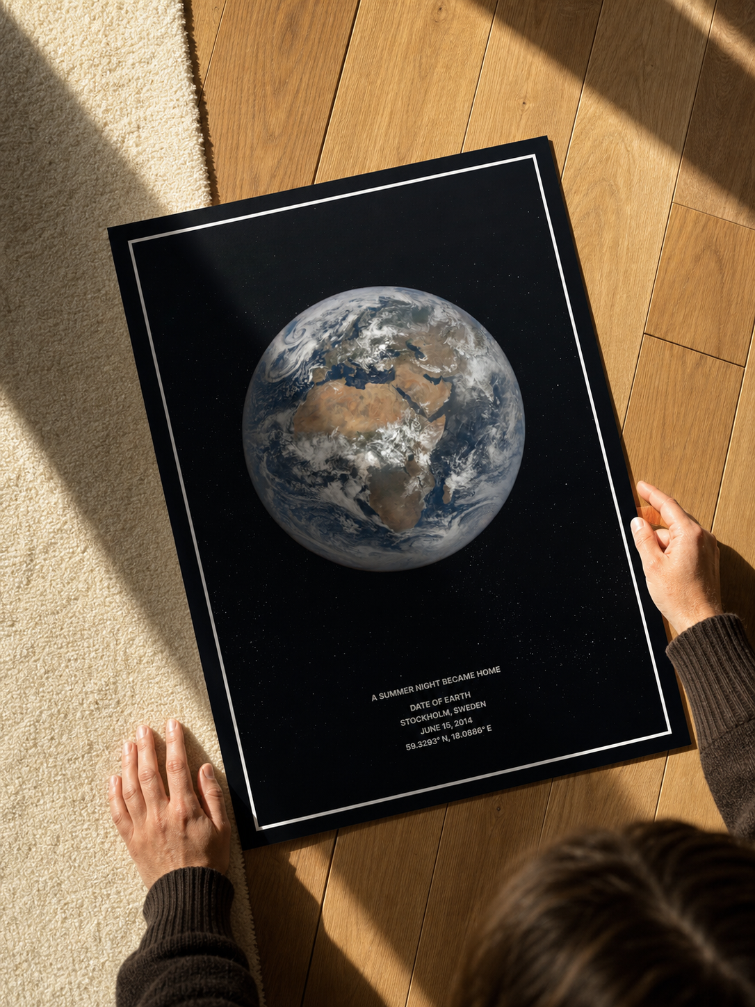 Black framed Date of Earth print with a full-disc Earth image held in two hands.